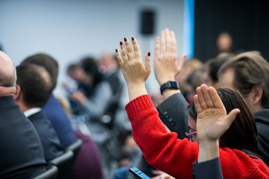  businessman raising hand during seminar. Businessman Raising Hand Up at a Conference to answer a question.