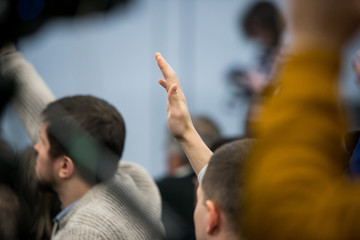  businessman raising hand during seminar. Businessman Raising Hand Up at a Conference to answer a...