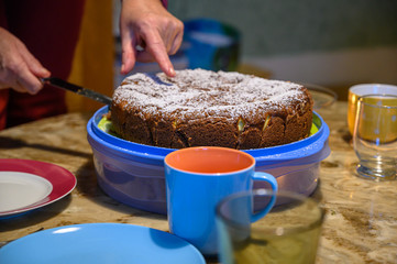 Take a piece of cake from a cake on a coffee table