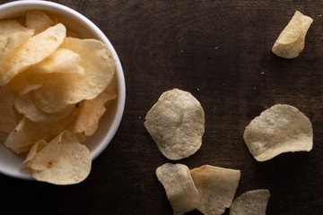 Potato chips scattered on table .