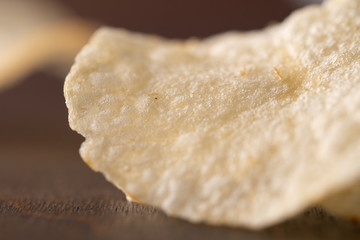 Potato chips scattered on table .