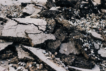 Destroyed asphalt. Repair the road. mountains of sand and stones