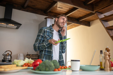 Man calling to his girlfriend to ask about the recipy