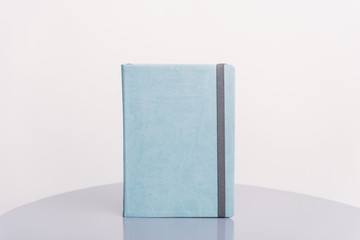 Gray book, agenda or planner standing on a grey surface and white background. Book template.