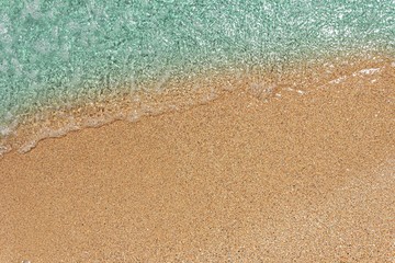 background with blue sea wave on sandy beach top view with copy space