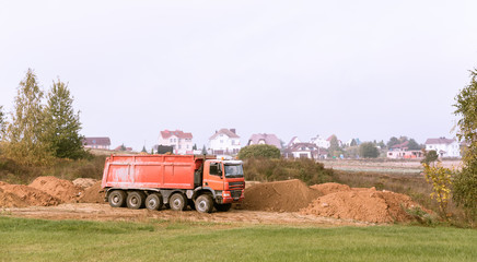 A large 70-ton dump truck brought sand to a new construction site to add land
