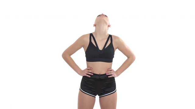 Young athletic woman doing fitness exercises for neck health. She is turning her head. Isolated studio shot on white background