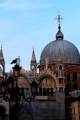 Fototapeta na wymiar Venice, Italy, December 28, 2018 evocative image of the dome of the Basilica of San Marco on the background with a seagullperched on a lamppost in the foreground