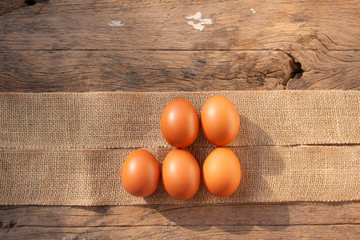5 eggs  on brown cloth with wooden background.