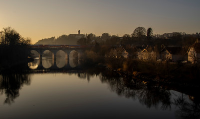 Obraz premium old stone bridge over the river at sunset in autumn in bavaria