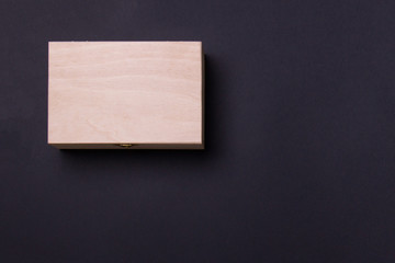 wood box lying on black background in left corner, top view with copy space