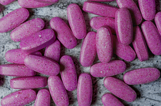 Vitamins in purple tablets. View from above.