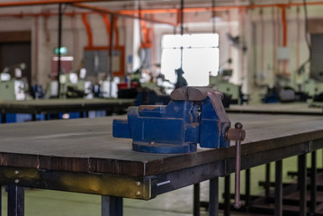 Metal workshop. Vise and bench grinder on workbench. Copy space.