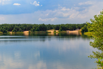 Fototapeta na wymiar View of a beautiful lake in a pine forest at summer