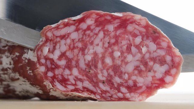 chef sliced sausages salami in white mold closeup. cured sausages. white background