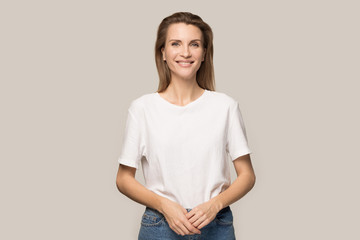 Fototapeta premium Portrait of smiling millennial woman posing for picture in studio