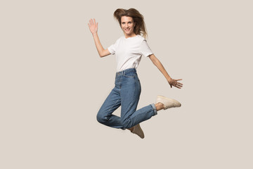 Fototapeta na wymiar Active young woman jump high posing in studio