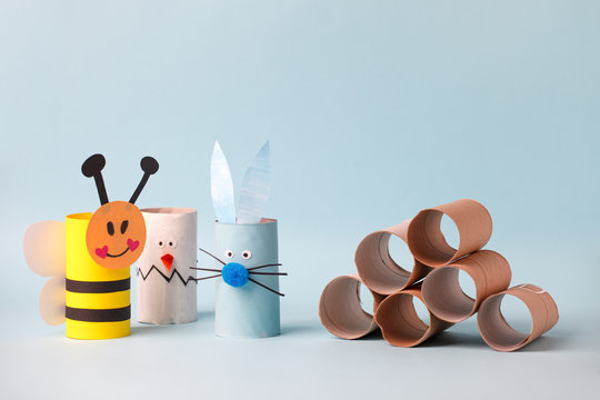 Paper toy rabbit, chicken egg for happy Esater party. Easy crafts for kids on blue background, copy space, diy creative idea from toilet tube roll, recycle reuse eco concept