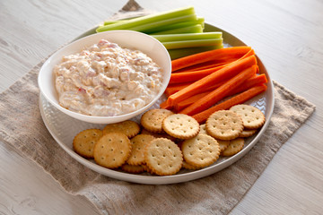 Homemade Pimento Cheese Dip with carrots, celery and crackers, side view. Close-up.