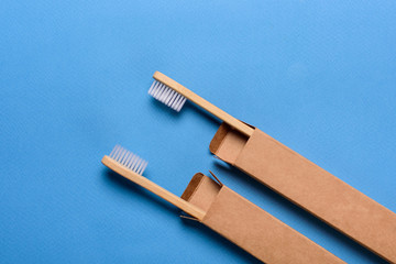 Bamboo toothbrushes on blue background, top view