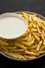 Homemade Crispy Ranch Fries on a black background, low angle view. Close-up.