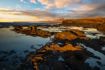 Rocky cliff in Fuerteventura in the warm light of the setting sun. Near Morro Jable