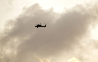 The helicopter fly high in the sky in the morning