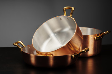 New copper cooking ware over dark background