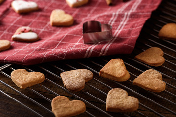 homemade cookies hearts on Burgundy cloth towel and metal grate