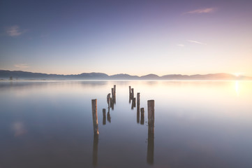Fototapeta na wymiar Wooden pier or jetty remains and lake at sunrise. Torre del lago Puccini Versilia Tuscany, Italy