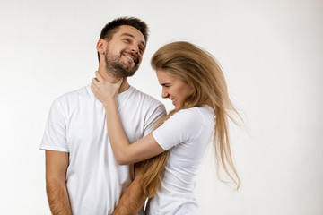 woman jokingly strangles man. angry woman shouting at her happy boyfriend on white background.