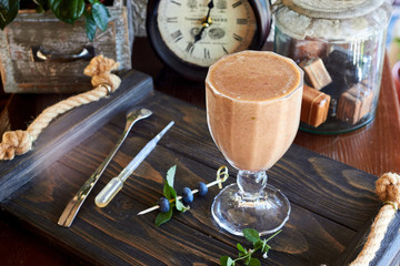 Blueberry smoothie or black currant purple milkshake with mint in the vintage interior of the cafe