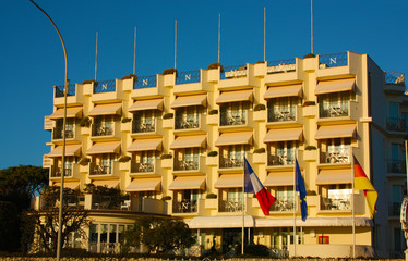 large luxury hotel seen from the main facade for rich and important people for royal stays in the structure for overnight stays with balconies and windows and flags
