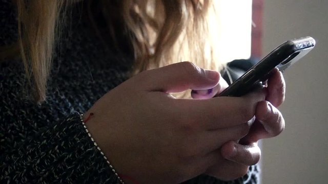 Mujer rubia utilizando tel&eacute;fono m&oacute;vil