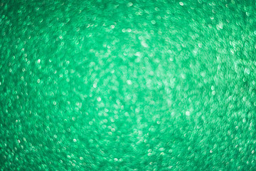 Green bright abstract background with bokeh. Festive sparkles, magic backdrop