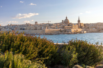 Panoramic view of Valletta, seafront skyline of the capital city of Malta from Sliema shoreline with green flora