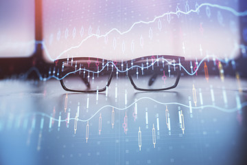 Financial graph hologram with glasses on the table background. Concept of business. Double exposure.