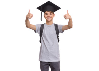 Young graduate student - Happy teen boy in bachelor hat with backpack, isolated on white background. Smiling child In Corner-Cap making Thumb up Gesture. Teenager guy in Graduation Cap Back to school.