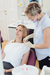 Dental nurse attaching a bib to a patient
