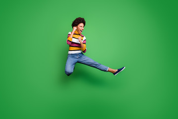 Full length photo of funny crazy afro american girl jump practice autumn sportive kickboxing kick legs fists fight enemy copyspace wear shine beautiful outfit isolated green color background