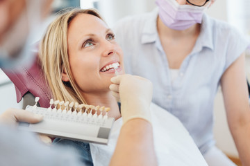 Dentist checking the whiteness of a patients teeth