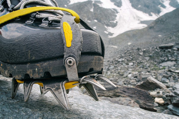 Mountain climbing boot with crampon in alpine landscape.