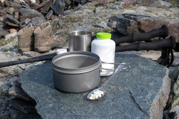 Sports nutrition for climbers. Breakfast for climbers and hikers on the stone table in alpine landscape.