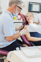 Fototapeta premium Smiling woman listening to a dentist in a surgery