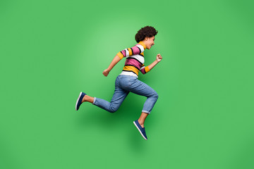 Fototapeta na wymiar Full size profile side photo of funky afro american girl jump run after incredible black friday fall discounts wear stylish clothing isolated over green color background