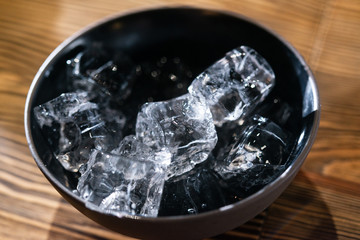 Close up view of ice cubes in the ceramic dark bowl