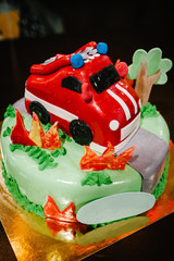Festive baby cake with fire truck, car. The concept of celebrating a child's birthday. Close-up.