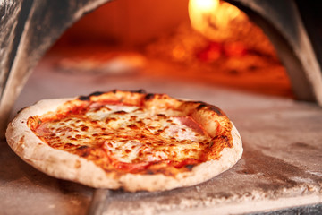 Gebackene leckere Margherita-Pizza im traditionellen Holzofen im Restaurant Neapel, Italien. Original neapolitanische Pizza. Glühende Kohle.