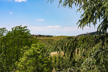 Classic Italian landscape in Tuscany with vineyards, cypresses, hills in late spring