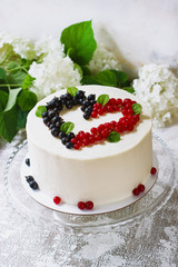 Round white cake with berries in the form of hearts, Valentine's Day, on white background. Picture for a menu or a confectionery catalog. Top view